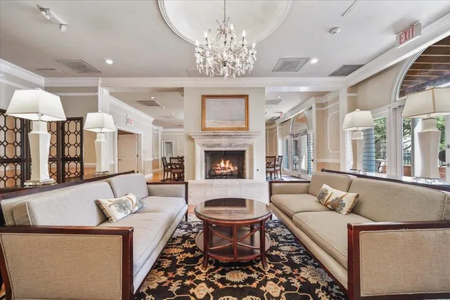 a living room with furniture a chandelier and a fireplace