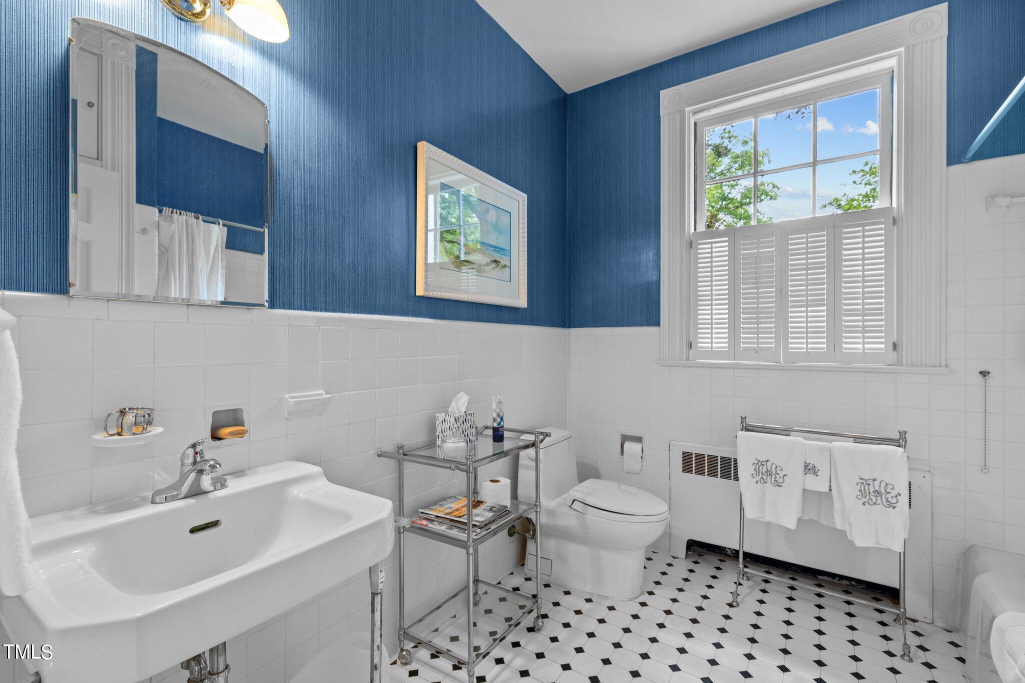 3116 Cornwall Road Durham, NC 27707 - Photo 30 of 85 a bathroom with a sink toilet a mirror and a window