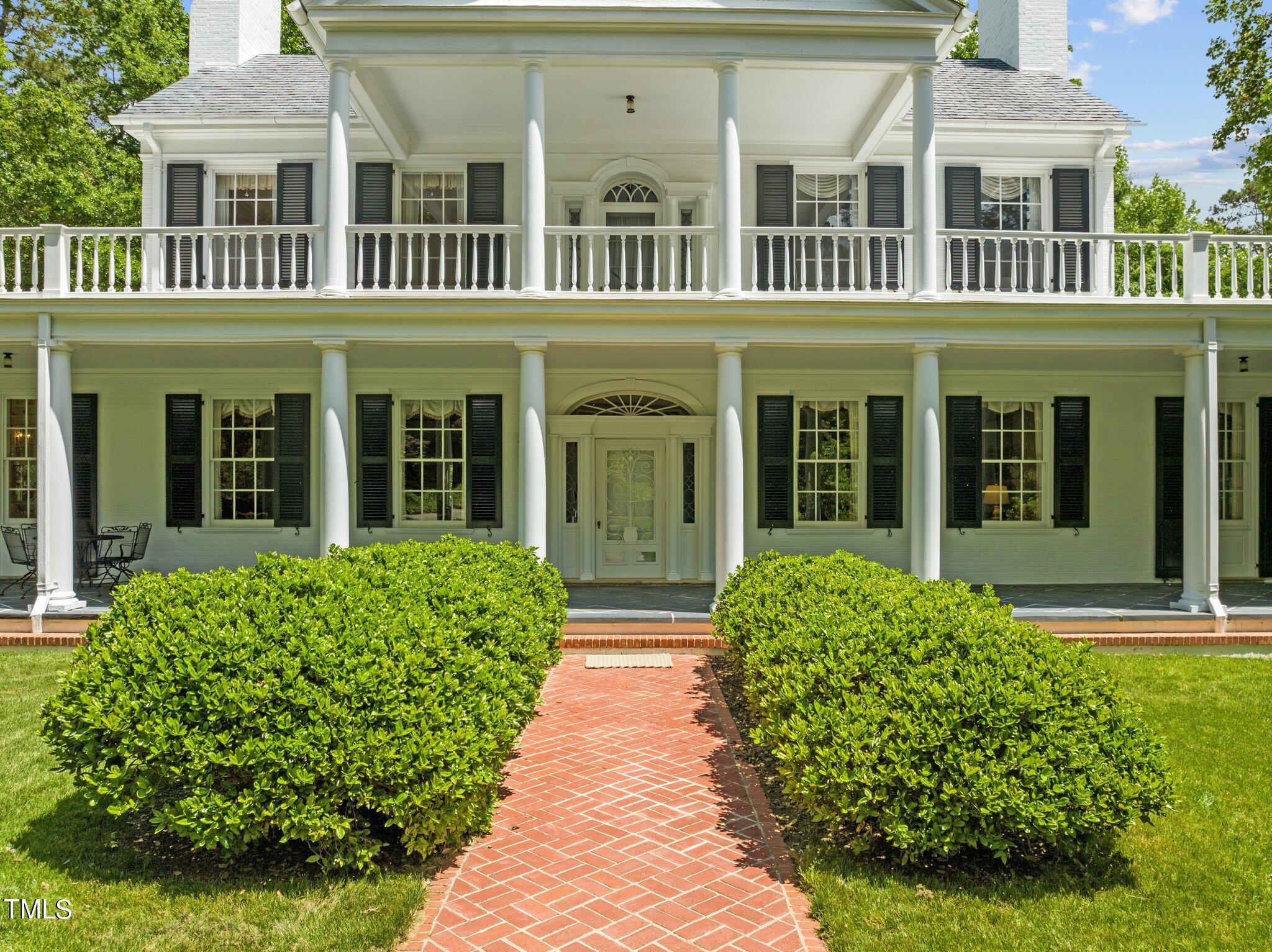 3116 Cornwall Road Durham, NC 27707 - Photo 71 of 85 front view of a brick house with a large window plants and palm trees