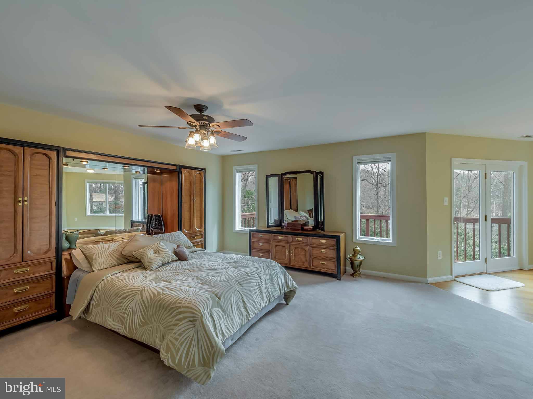 13110 Soundings Road Lusby, MD 20657 - Photo 22 of 30 a bedroom with a large bed and a chandelier fan
