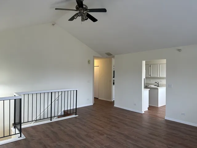 a view of a hallway with wooden floor and windows