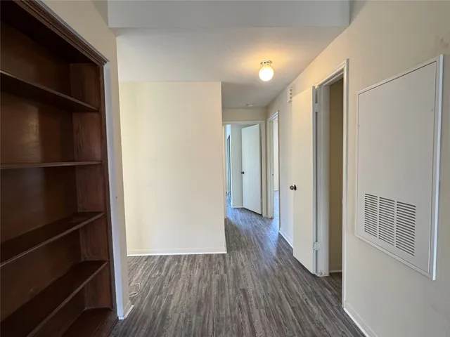 a view of a hallway with wooden floor and closet