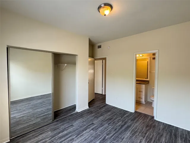 an empty room with wooden floor and closet