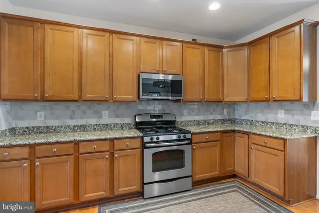 a kitchen with granite countertop cabinets stainless steel appliances and sink