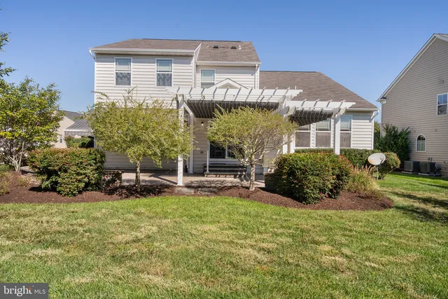 a view of a brick house with a big yard and potted plants