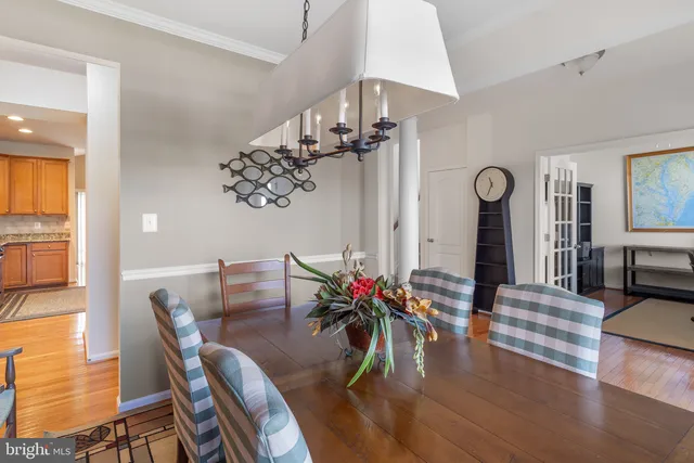 a view of a dining room and livingroom with furniture wooden floor a chandelier