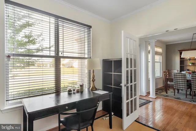 a view of a workspace with furniture and a window