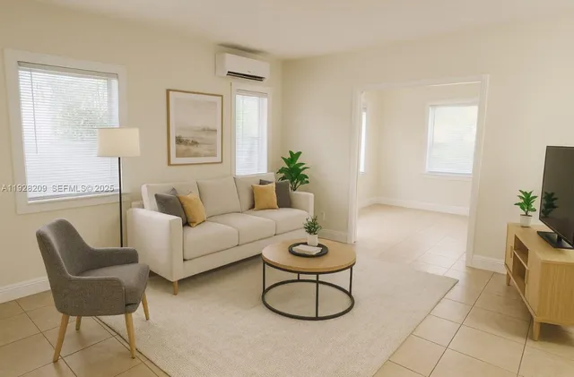 a living room with furniture a flat screen tv and a window