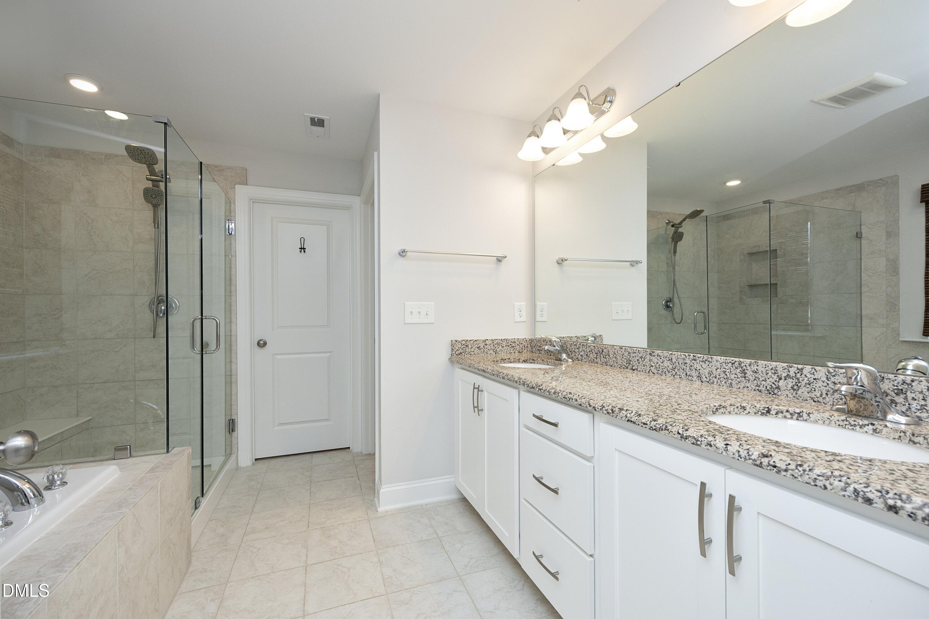 500 Ressler Street Holly Springs, NC 27540 - Photo 14 of 37 a spacious bathroom with a granite countertop sink a mirror and a shower