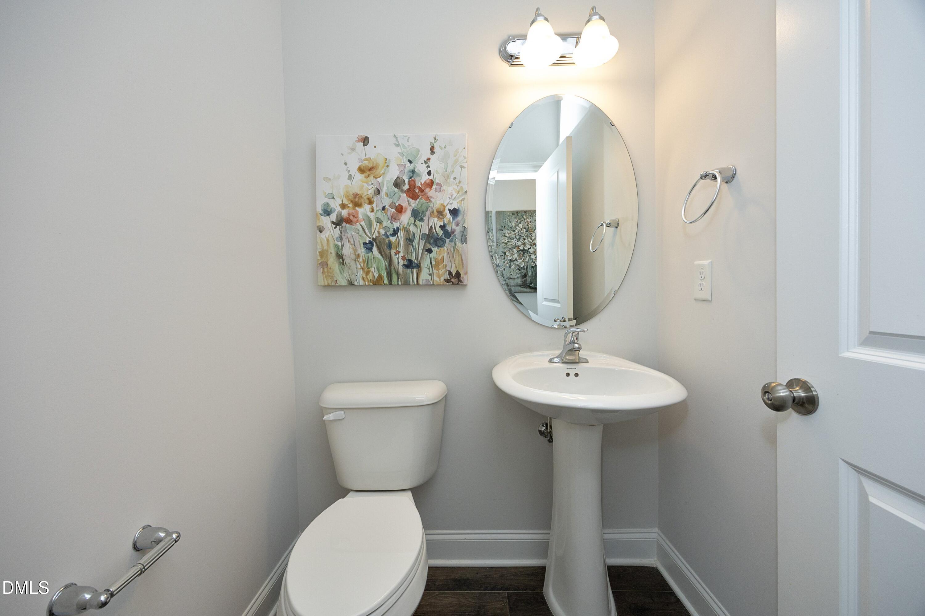 500 Ressler Street Holly Springs, NC 27540 - Photo 24 of 37 a bathroom with a toilet a sink and a mirror