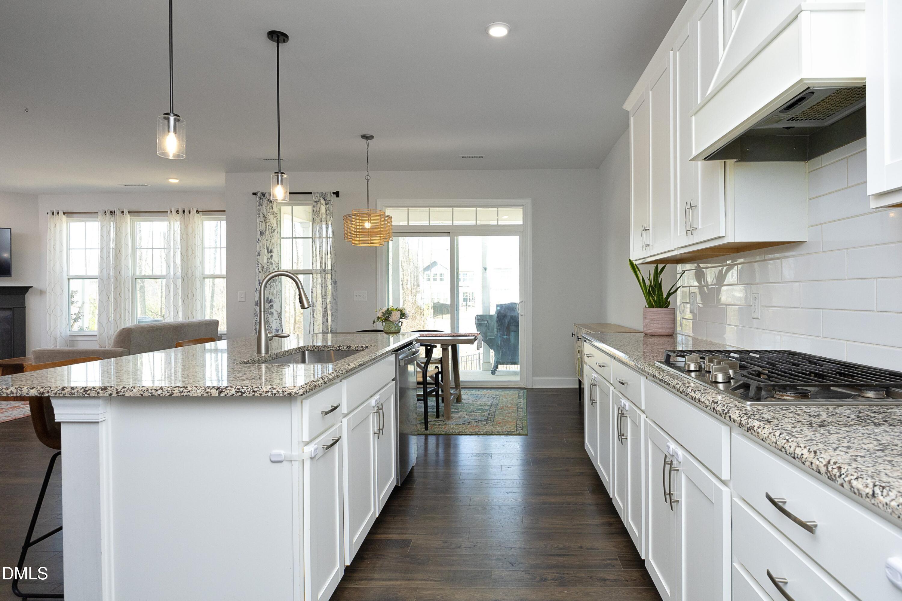 500 Ressler Street Holly Springs, NC 27540 - Photo 3 of 37 a kitchen with stainless steel appliances granite countertop a stove a sink and a wooden floors