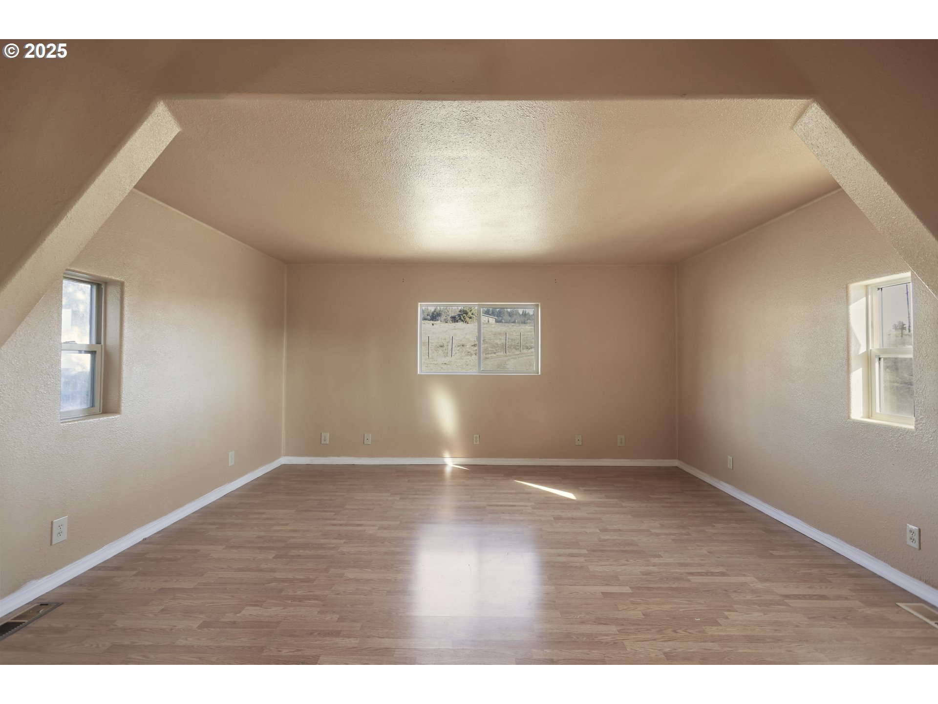 401 Johnson Road Lyle, WA 98635 - Photo 16 of 48 a view of an empty room with wooden floor and a window