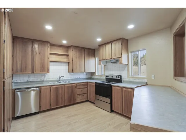 a kitchen with stainless steel appliances granite countertop a sink stove and refrigerator