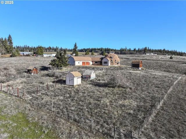 a view of a dry yard with wooden fence