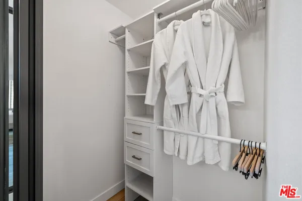 a view of walk in closet with clothes