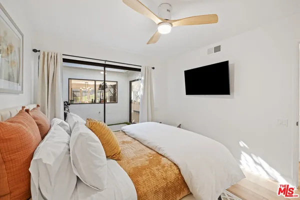 a bedroom with a large bed and a flat screen tv