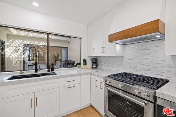a kitchen with white cabinets and appliances