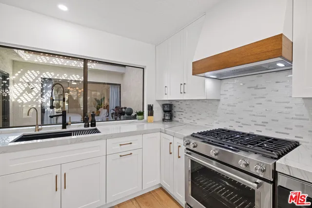 a kitchen with white cabinets and appliances