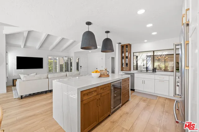 a kitchen with stainless steel appliances a stove top oven and a wooden floors