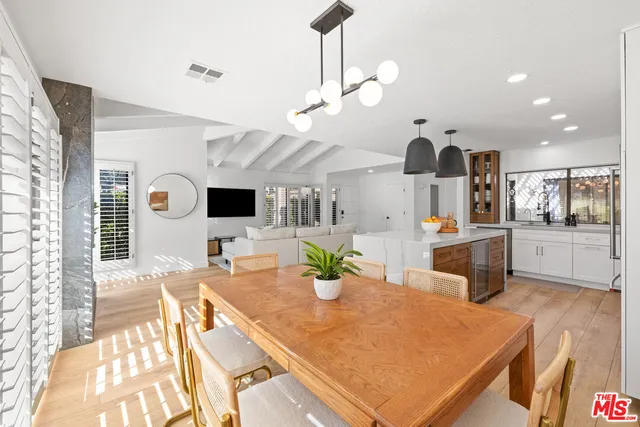 a kitchen with stainless steel appliances kitchen island granite countertop a table and chairs in it