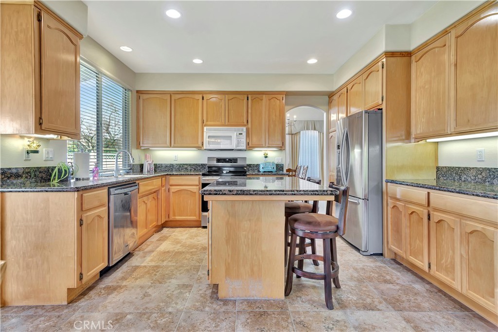 2104 Summit Drive Paso Robles, CA 93446 - Photo 12 of 31 a kitchen with stainless steel appliances granite countertop a stove a sink a refrigerator and white cabinets with wooden floor