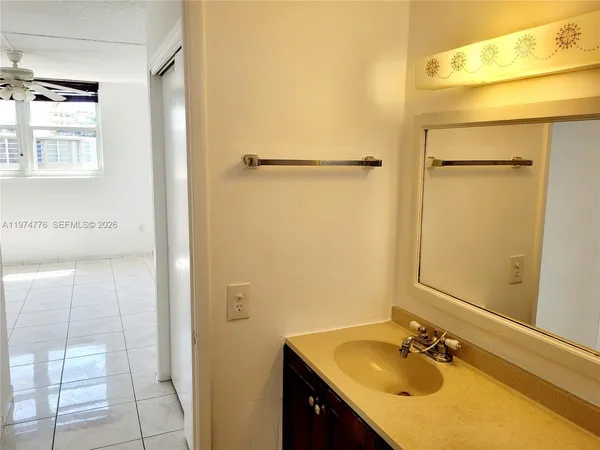 a bathroom with a sink vanity granite and shower