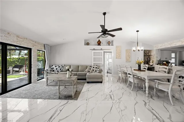 a living room with furniture and floor to ceiling windows