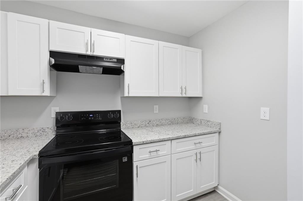 6981 Flagstone Drive Austell, GA 30168 - Photo 13 of 34 a kitchen with stainless steel appliances granite countertop white cabinets and a stove