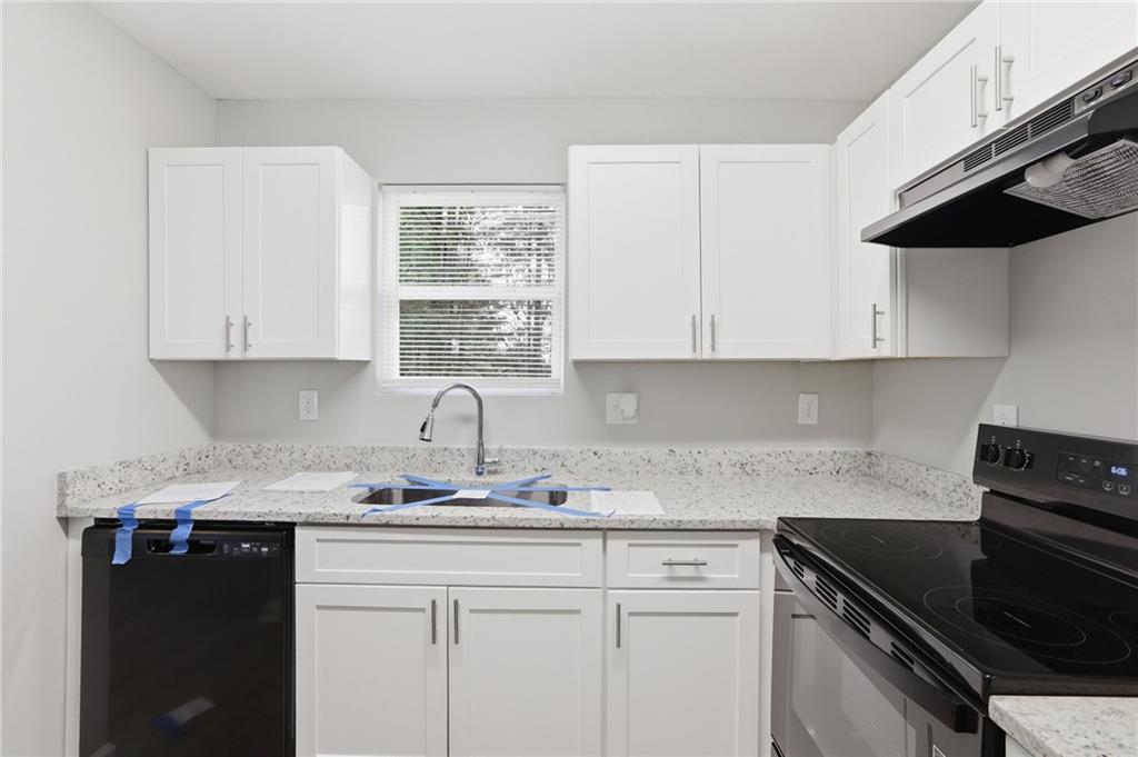 6981 Flagstone Drive Austell, GA 30168 - Photo 14 of 34 a kitchen with granite countertop white cabinets and black appliances