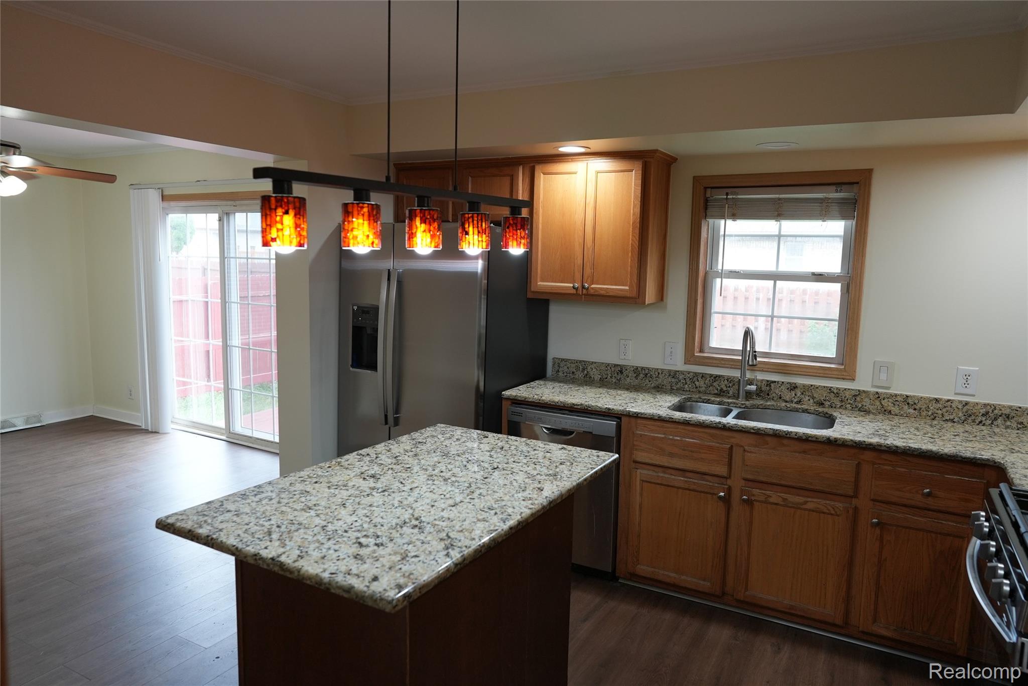 2018 John R Road Troy, MI 48083 - Photo 13 of 57 Kitchen featuring wood-finish flooring, an island with a stone-finish countertop, wood cabinetry, and stainless steel appliances