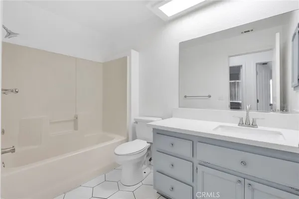 a bathroom with a granite countertop sink a toilet and bathtub