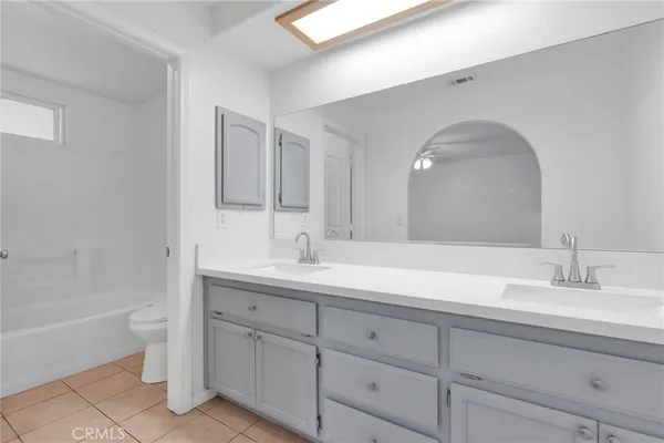 a bathroom with a double vanity sink a mirror and a bathtub