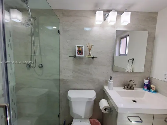 a bathroom with a sink mirror and toilet