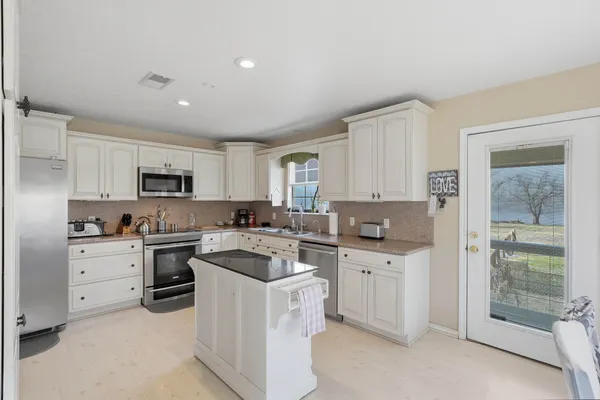 a kitchen with white cabinets and white appliances
