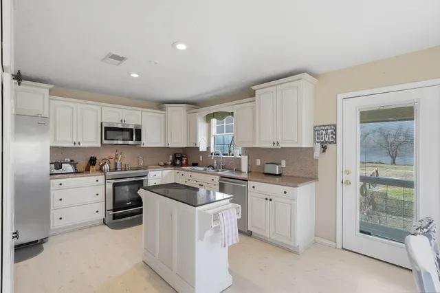 a kitchen with white cabinets and white appliances