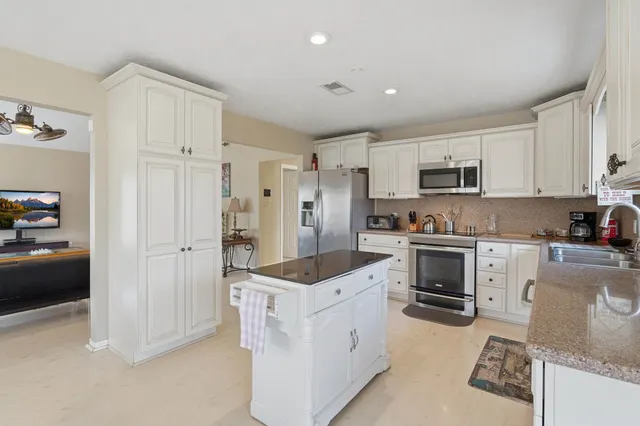 a kitchen with white cabinets and stainless steel appliances