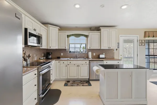 a bedroom with a large bed chandelier and a window