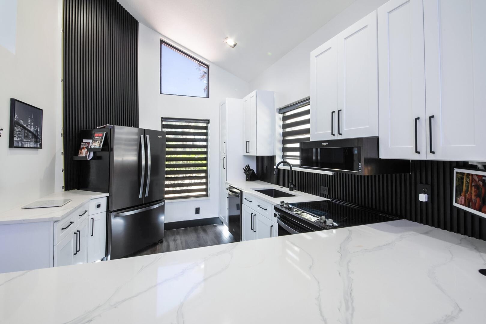 8658 Kimble Way Boca Raton, FL 33433 - Photo 10 of 33 a kitchen with stainless steel appliances kitchen island granite countertop a refrigerator stove top oven and sink