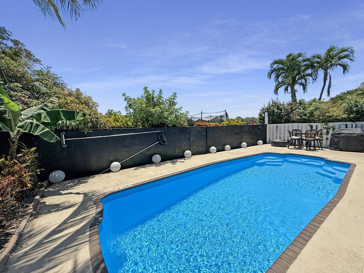 8658 Kimble Way Boca Raton, FL 33433 - Photo 23 of 33 a view of a swimming pool with a lounge chair and palm trees
