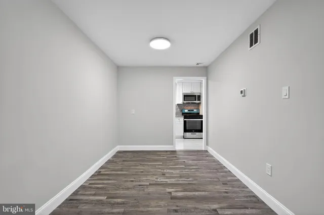 a view of empty room with wooden floor