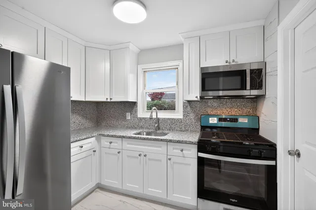 a kitchen with white cabinets and stainless steel appliances