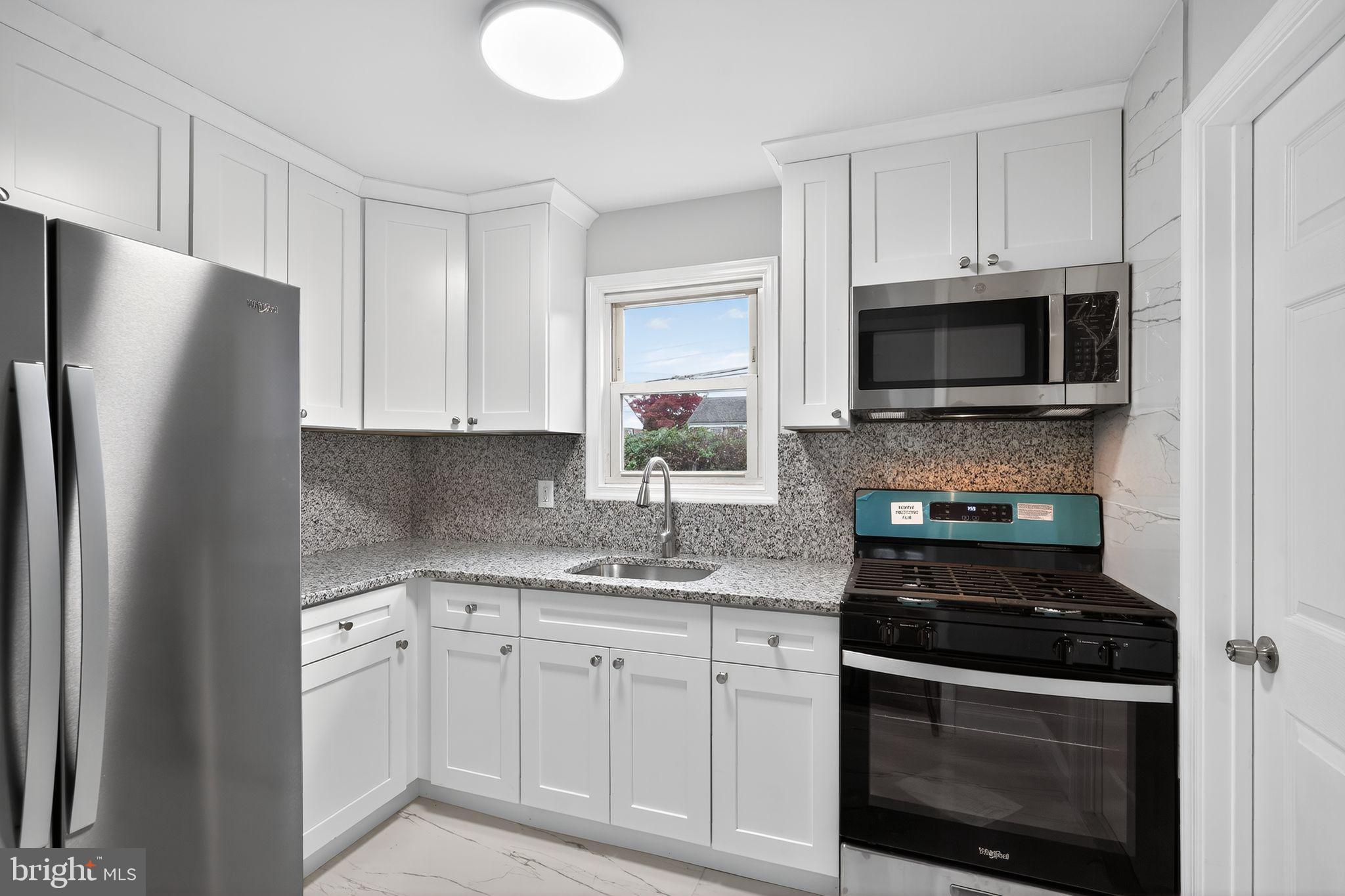 5706 Mitchell Road Levittown, PA 19057 - Photo 2 of 19 a kitchen with white cabinets and stainless steel appliances