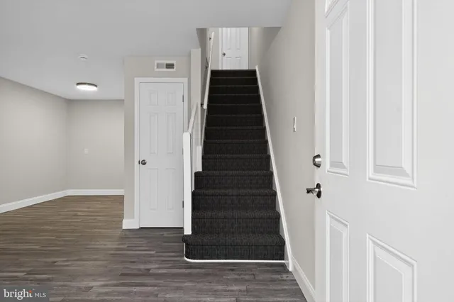 a view of a hallway with wooden floor and entryway