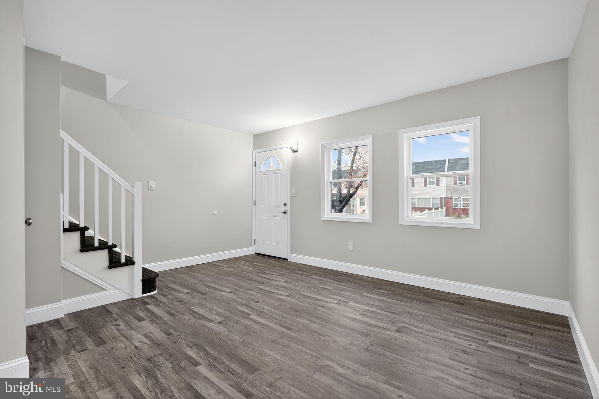 5706 Mitchell Road Levittown, PA 19057 - Photo 6 of 19 a view of an empty room with wooden floor and a window