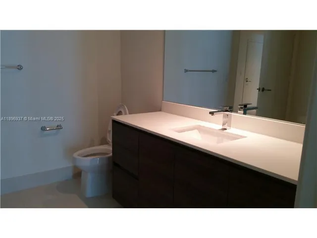 a bathroom with a sink a toilet a mirror and vanity