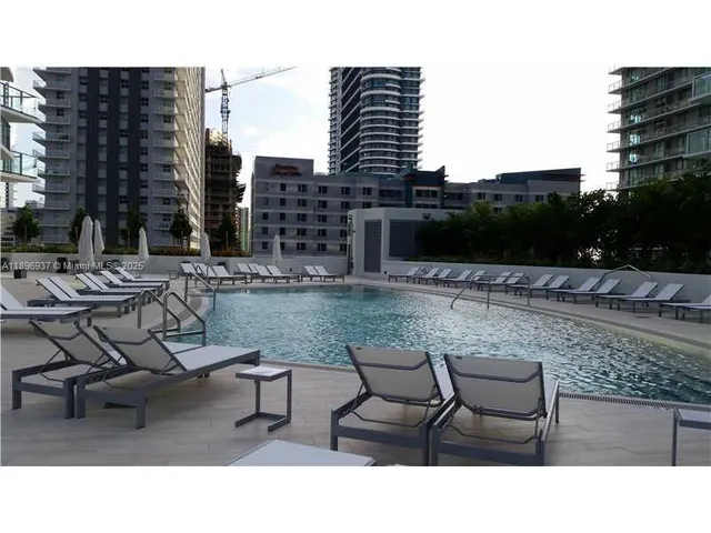 a swimming pool with outdoor seating and city view