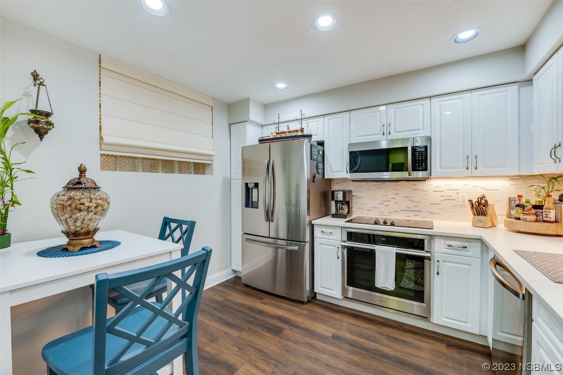 4620 Riverwalk Village Court, Unit 7206 Ponce Inlet, FL 32127 - Photo 3 of 48 a kitchen with stainless steel appliances a dining table chairs stove refrigerator and microwave