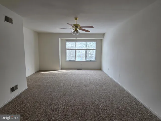 a view of a room with windows and ceiling fan
