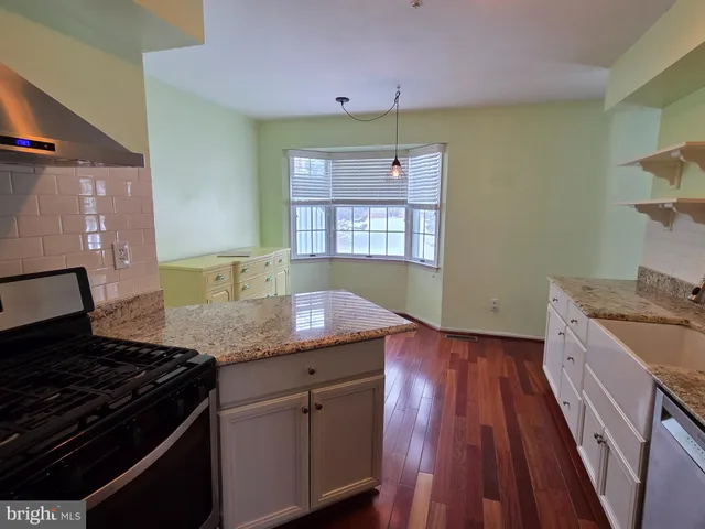 a kitchen with granite countertop a sink stove and cabinets