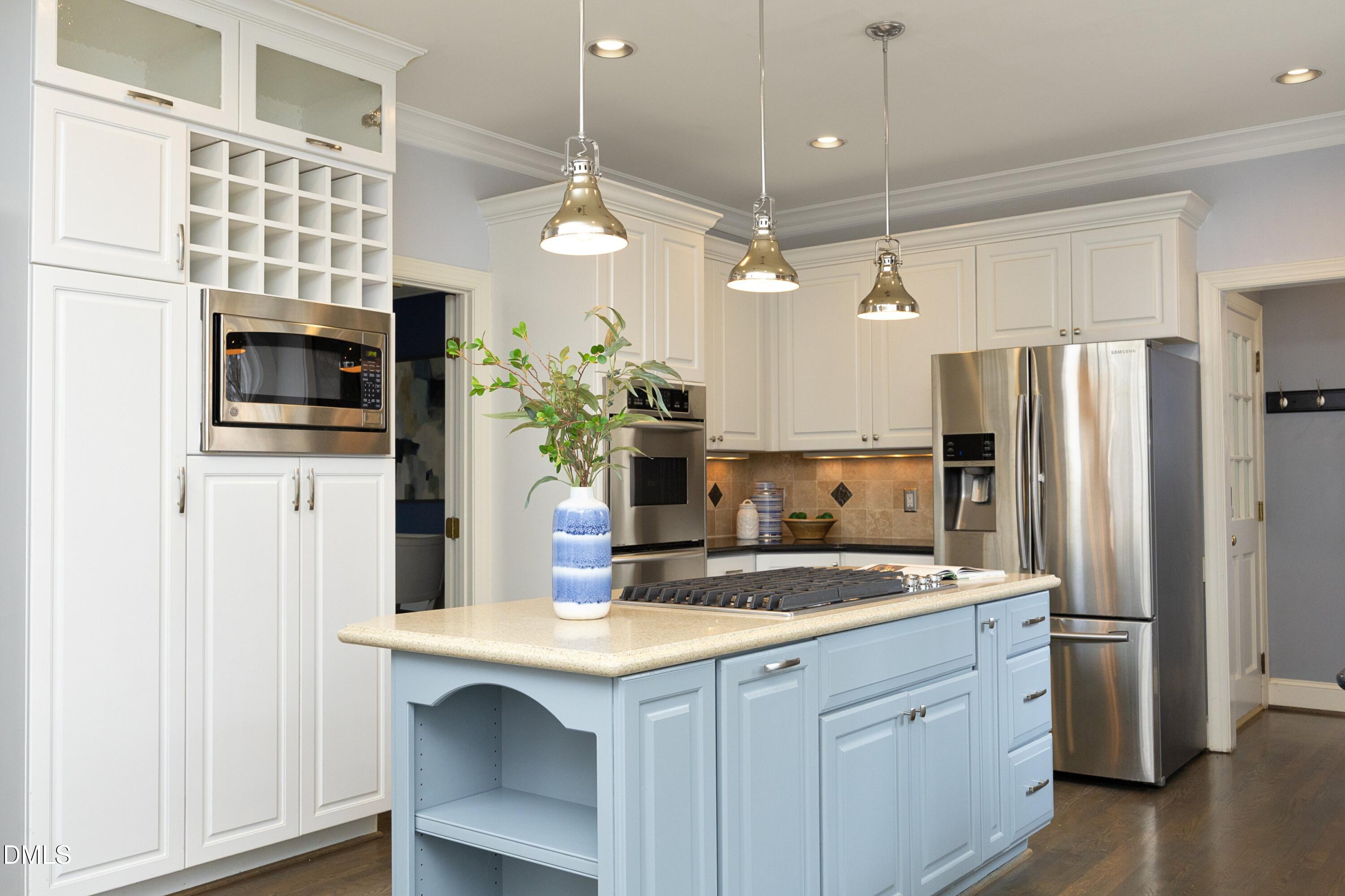 10728 Winding Wood Trail Raleigh, NC 27613 - Photo 14 of 54 a kitchen with kitchen island a sink stainless steel appliances and chandelier